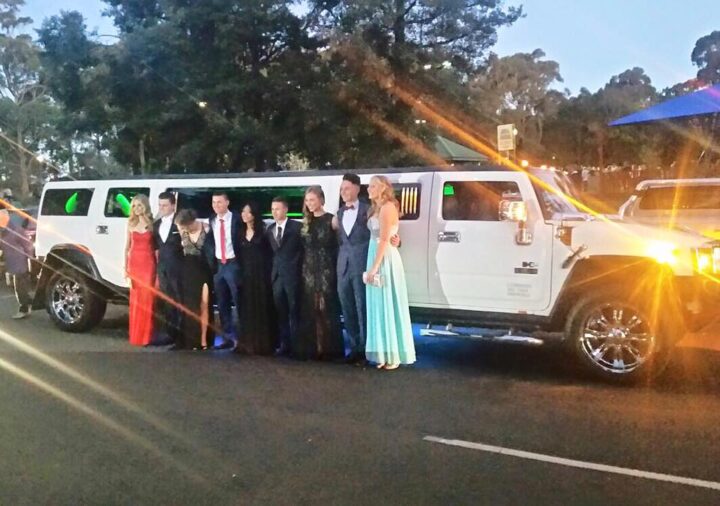 Multiple formal cars arriving together at a school formal venue