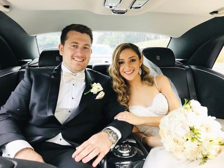 Bride and groom travelling in a chauffeured wedding car