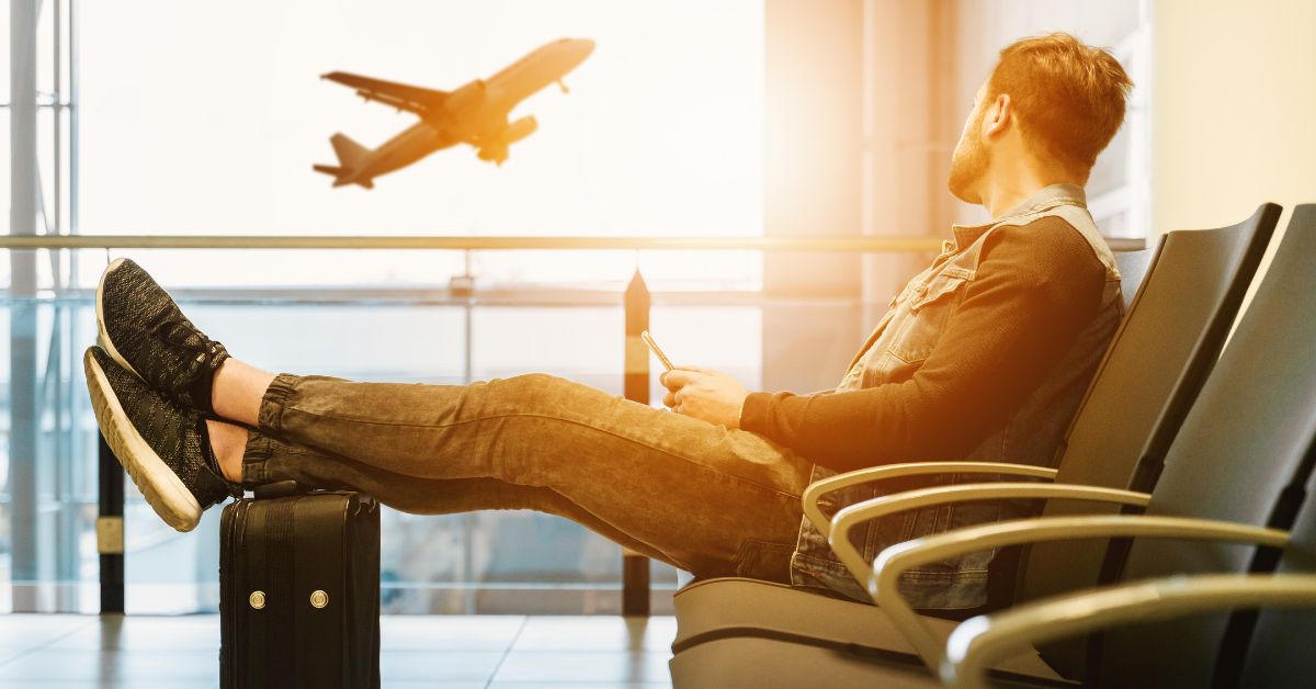 Man in airport waiting for boarding on plane.