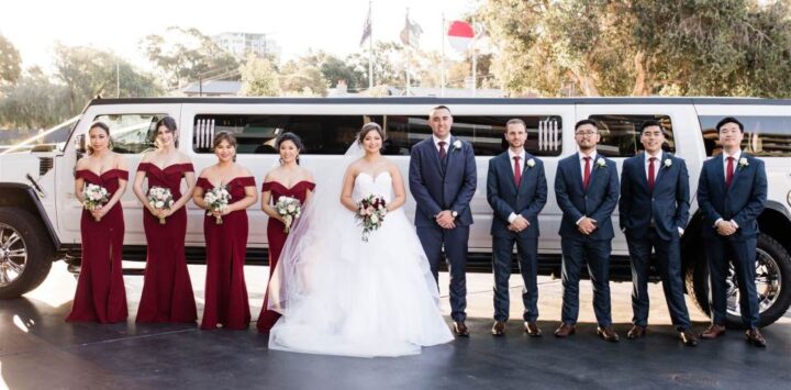 Bridal party and groomsmen with newly weds in front of our large super strecth Hummer.