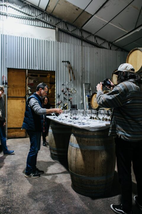 Sommelier pouring wine in winery.
