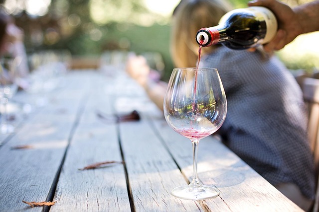 A hand pouring wine in a glass for tasting.