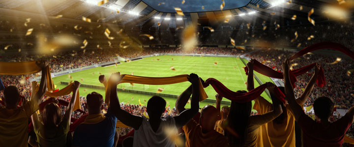 Football fans cheering their team on in the grand stand