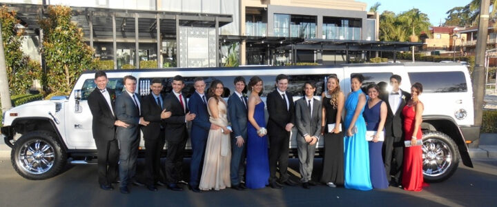School formal group taking photos beside coordinated luxury vehicles