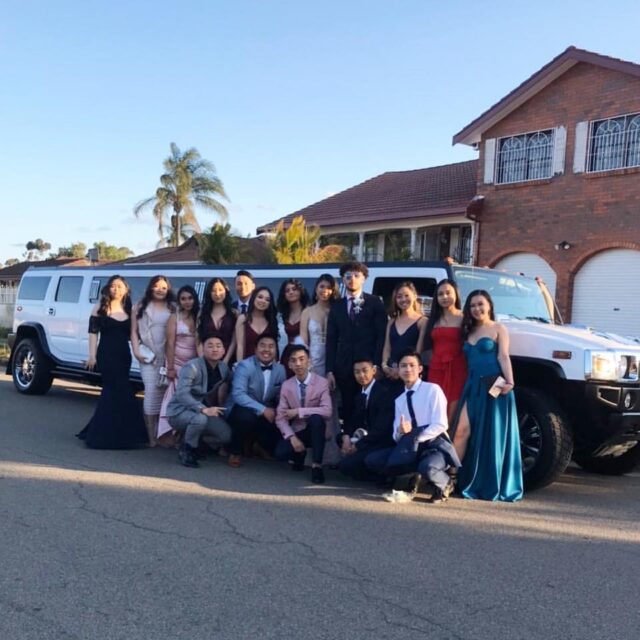 Students arriving in a group formal transport before a school formal