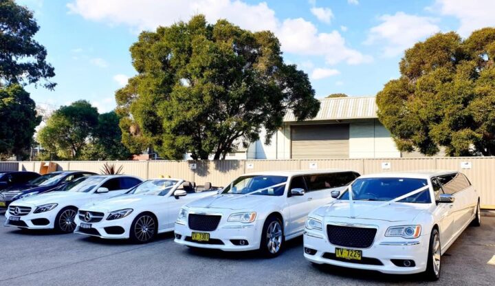 Multiple luxury wedding cars lined up outside a ceremony venue