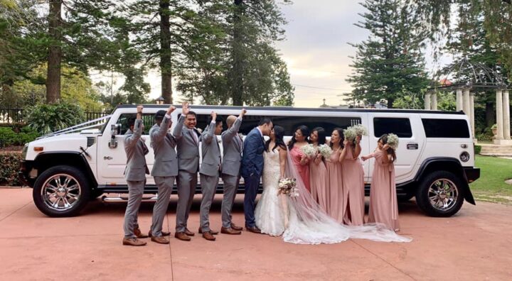 Congratulations to our couple Ariel and Arinne on their wedding day. The coupe kissing with bridesmaids and groomsmen either side and our stretch Hummer behind them